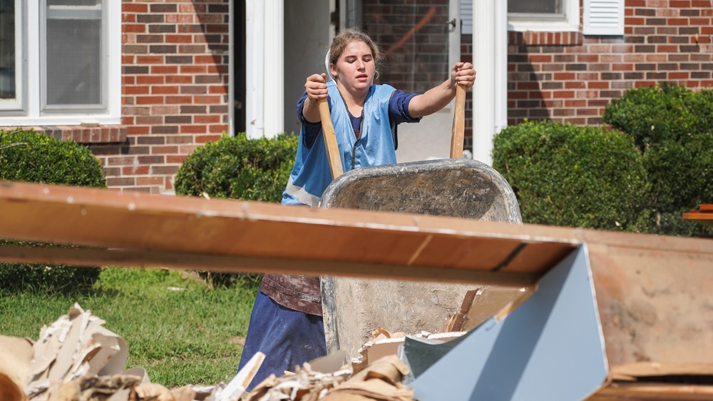 Dumping Debris in Front of Flooded House