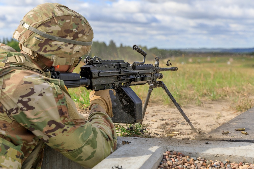 Spc. Nicholas Kyne fires an M249 machine gun