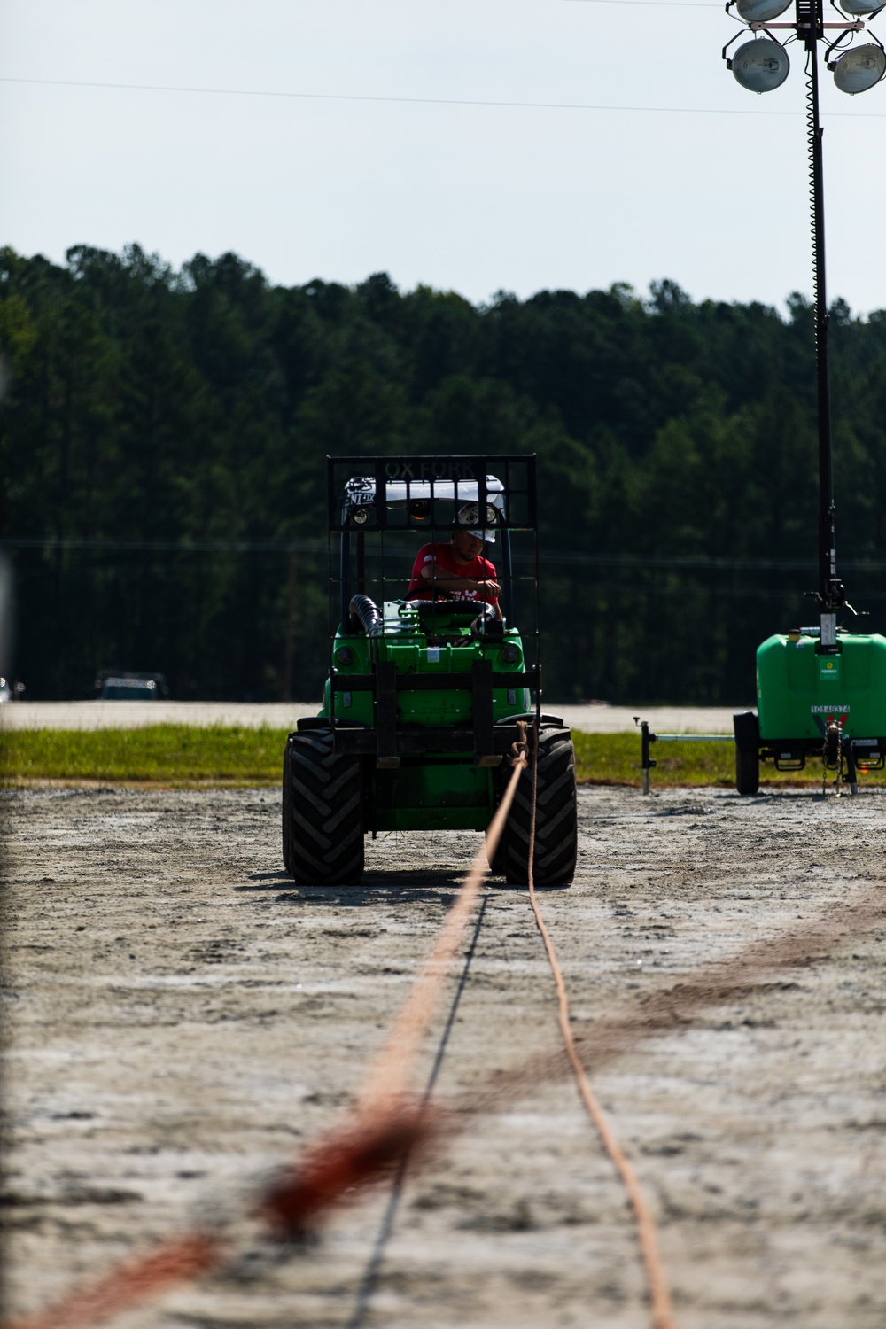 A Contract Worker helps to Pull a Large Plastic Tarp over New Residential Buildings at Fort Pickett, Virginia.