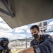 Sailors assigned to the forward deployed amphibious assault ship USS America perform maintenance on one of the ships radars.