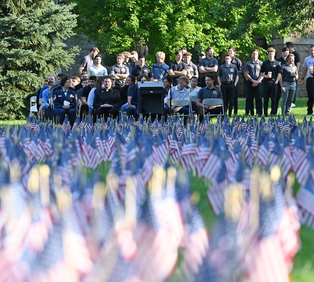 Spectators watch a 9/11 ceremony before a sea of flags