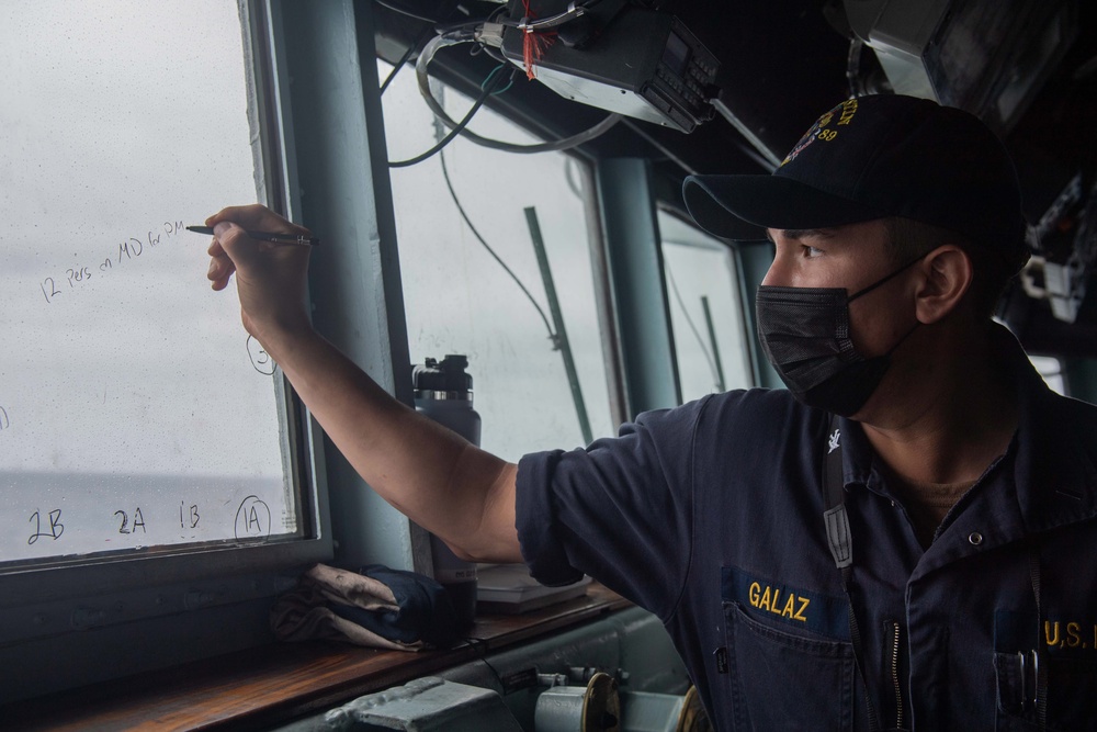 USS Mustin Sailor Records Information in the Pilothouse