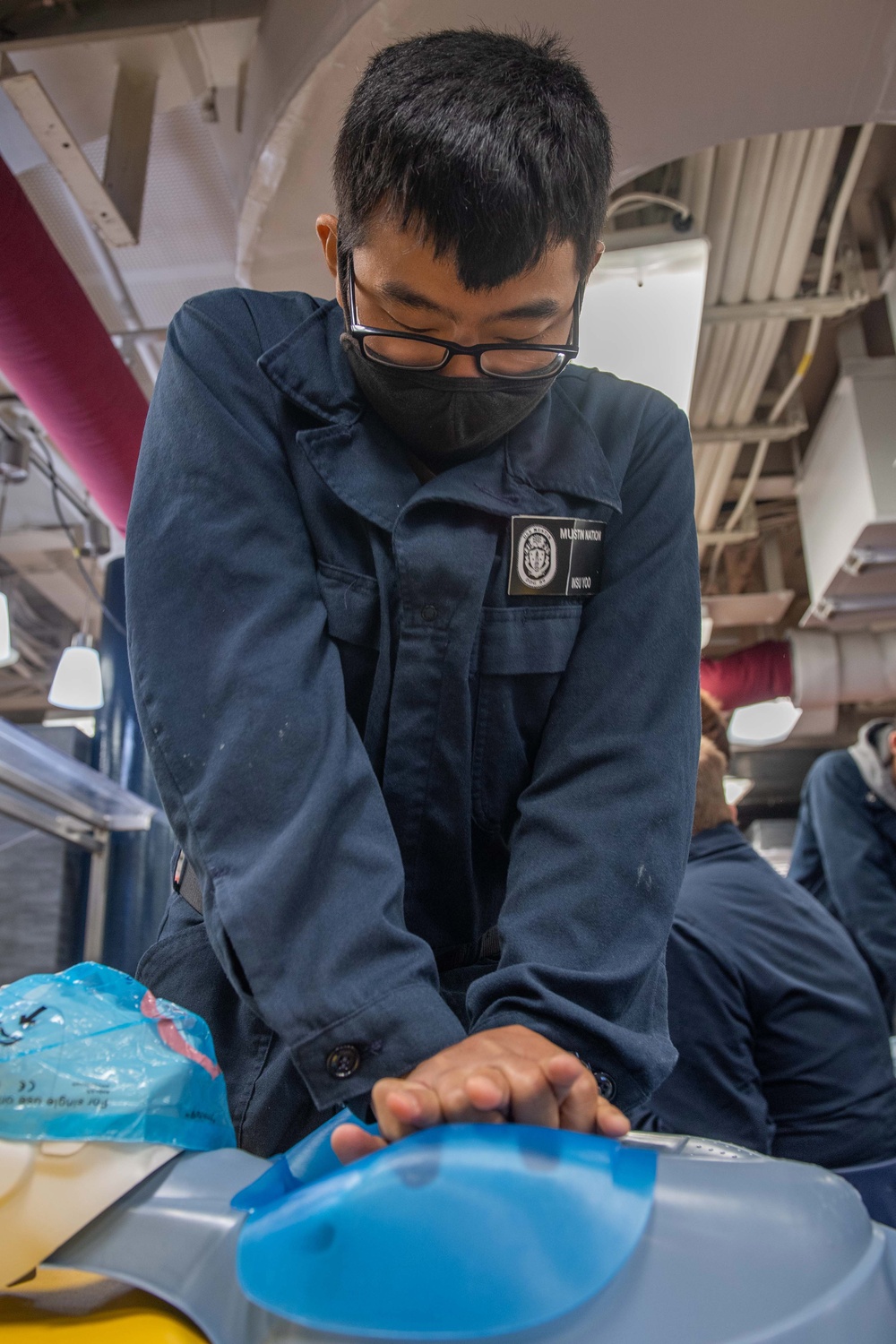 USS Mustin Sailor Practices Chest Compressions During First Aid Training