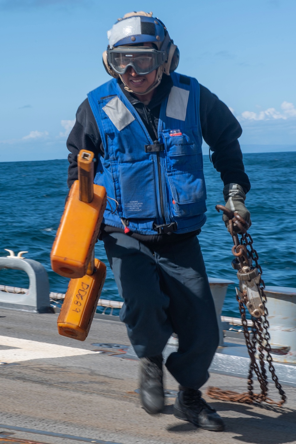 USS Mustin Sailor Removes Chocks and Chains From Aircraft Prior to Launch