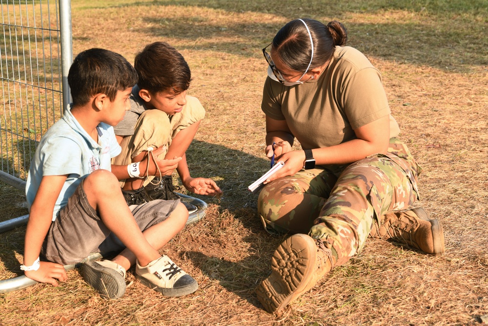 Military members and volunteers spend time with Afghan children