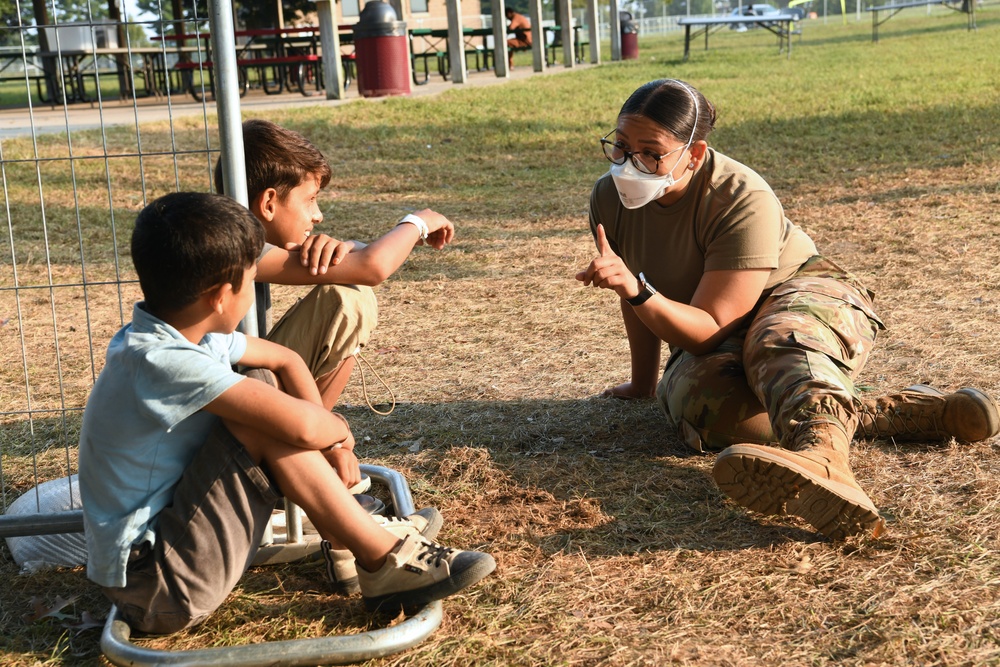 Military members and volunteers spend time with Afghan children