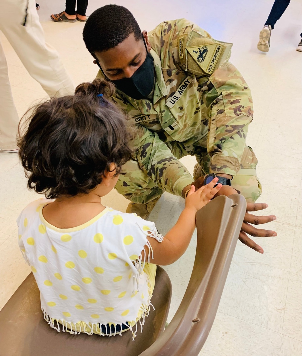 1st Lt. Roderick Britt, of 1st Battalion, 6th Infantry Regiment, 2nd Armored Brigade Combat Team, attends to a little girl after she was fitted for and received new shoes at the Doña Ana shoe-only donation building.
