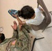 1st Lt. Roderick Britt, 1st Battalion, 6th Infantry Regiment, 2nd Armored Brigade Combat Team, attends to a little girl after she was fitted for and received new shoes at the Doña Ana shoe-only donation building.