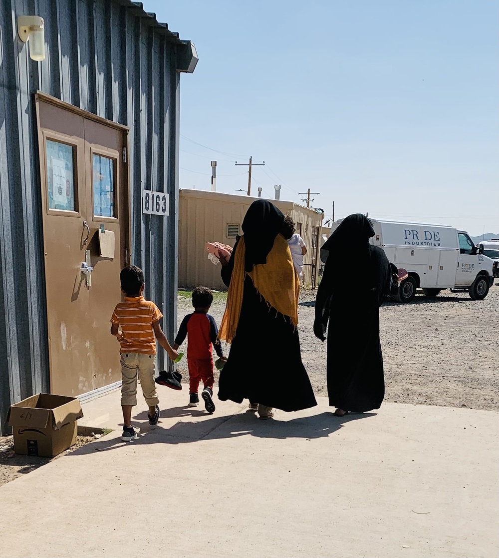 Two Mothers and three children depart the shoe-only donation building on Doña Ana Village.
