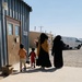 Two Mothers and three children depart the shoe-only donation building on Doña Ana Village.