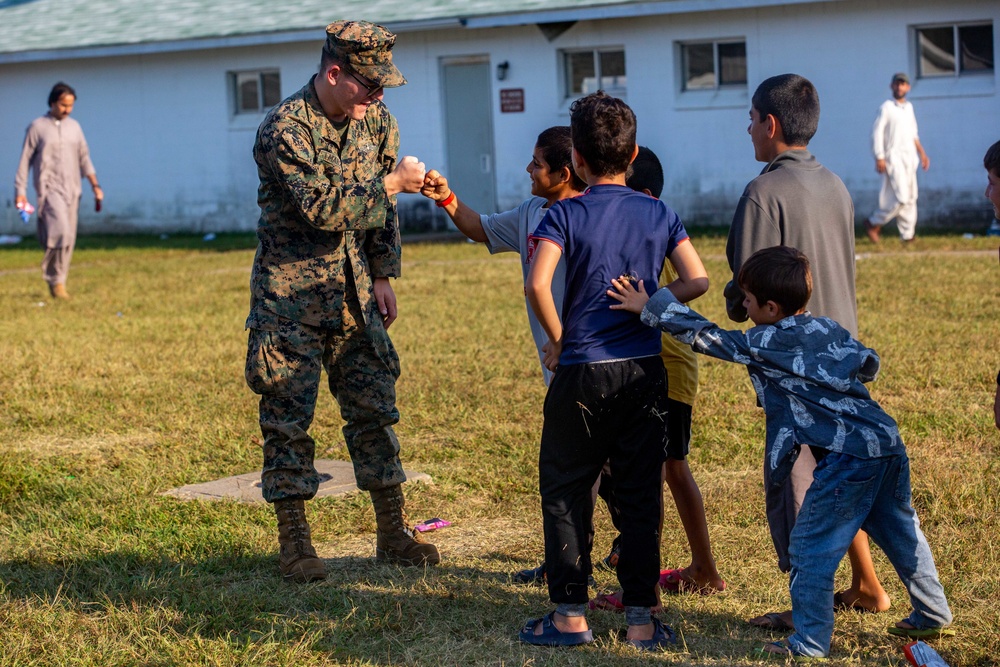 U.S. service members play with Afghan children during Operation Allies Welcome