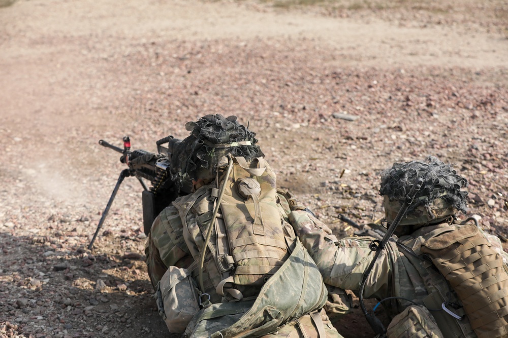 Team leader directs a squad automatic weapon to fire on an enemy target