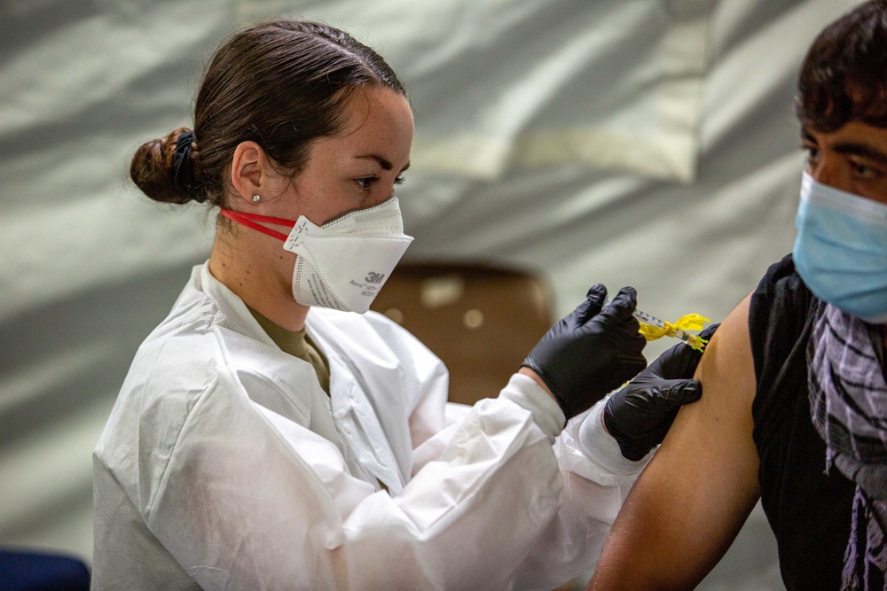 U.S. service members at Fort Pickett provide medical screening and vaccinations to Afghan civilians