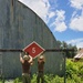 U.S. Navy Seabees assigned to NMCB-5 hang a battalion evaluation equipment program sign