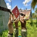 U.S. Navy Seabees assigned to NMCB-5 hang a battalion evaluation equipment program sign