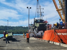U.S. Navy Seabees assigned to NMCB-5 receive civil engineer support equipment at Papua New Guinea