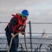 USS Mustin Sailor Coils Line During a Replenishment-At-Sea