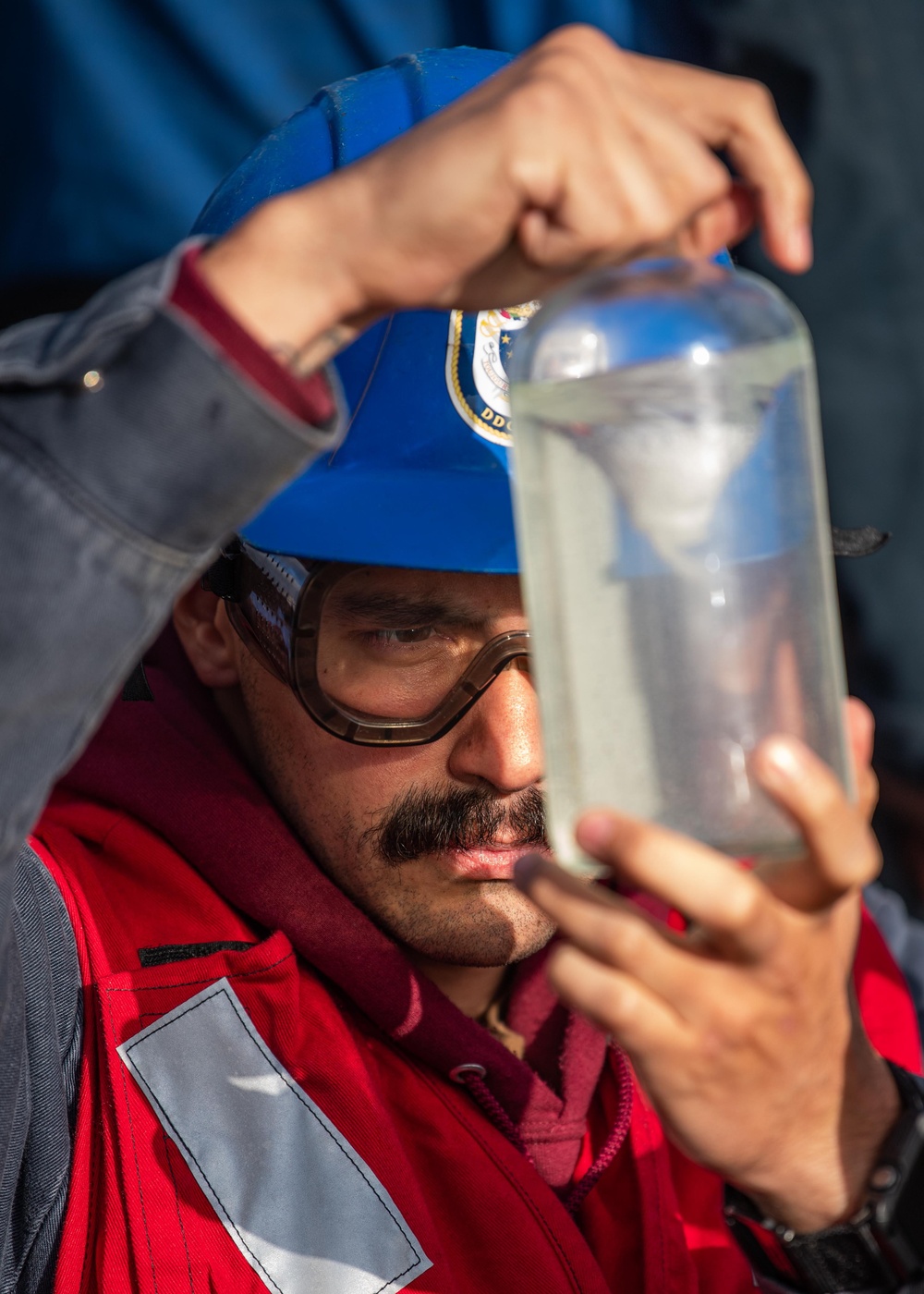 USS Mustin Sailor Inspects a Fuel Sample During a Replenishment-At-Sea