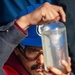 USS Mustin Sailor Inspects a Fuel Sample During a Replenishment-At-Sea