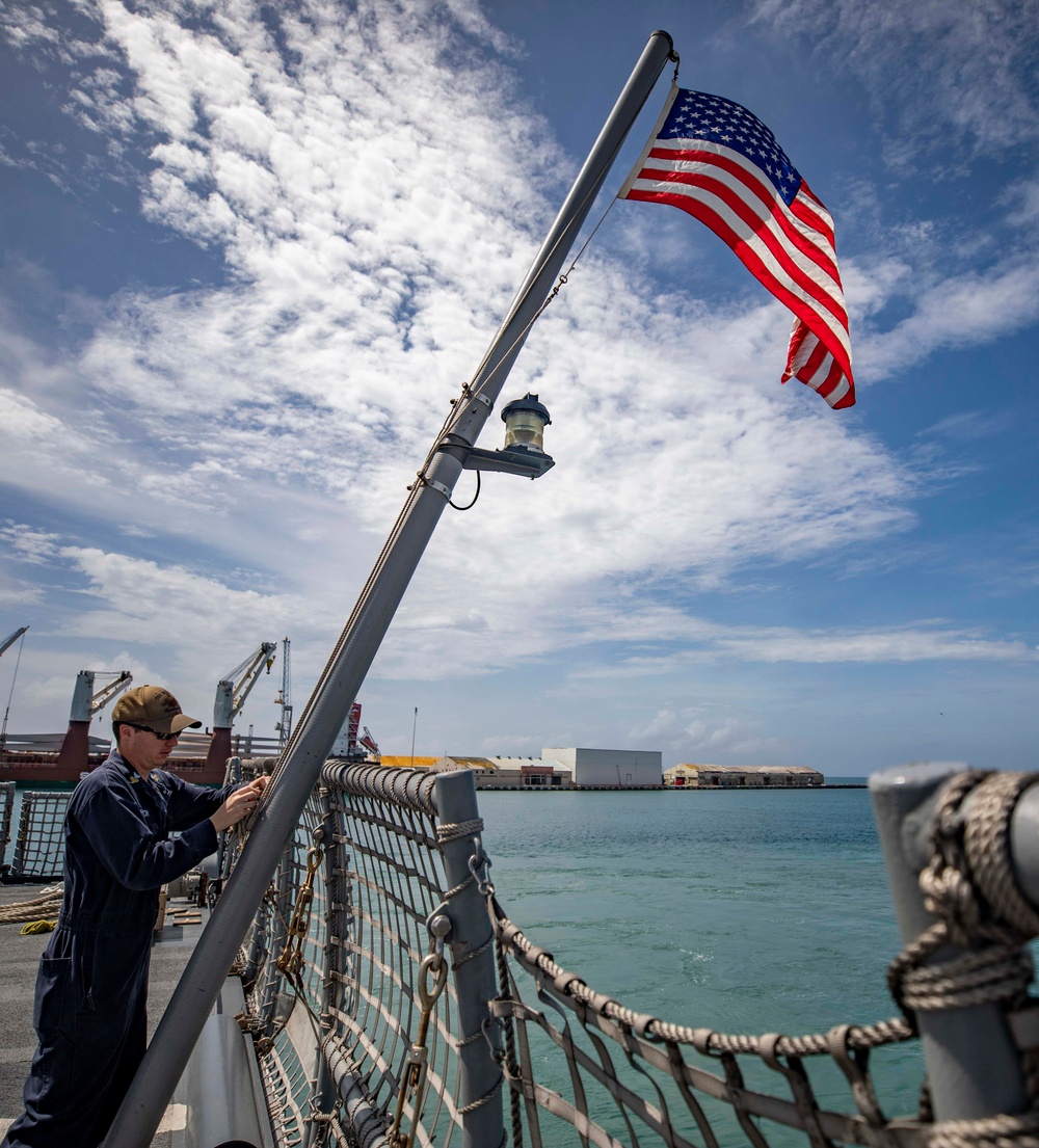 USS Billings Sailor Raises Ensign During Sea and Anchor Detail