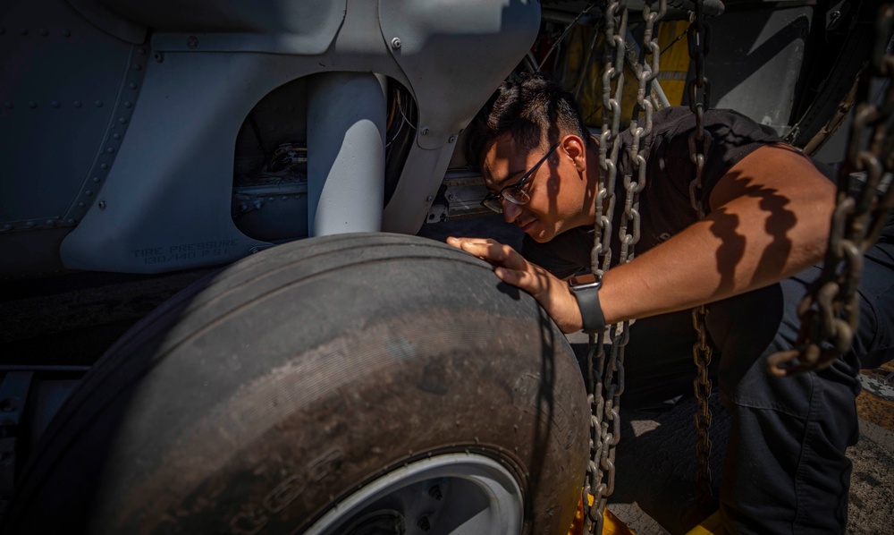 HSC 28 Sailor Inspects Landing Gear on an MH-60S Sea Hawk Helicopter HSC 28 Sailor Inspects Landing Gear on an MH-60S Sea Hawk Helicopter