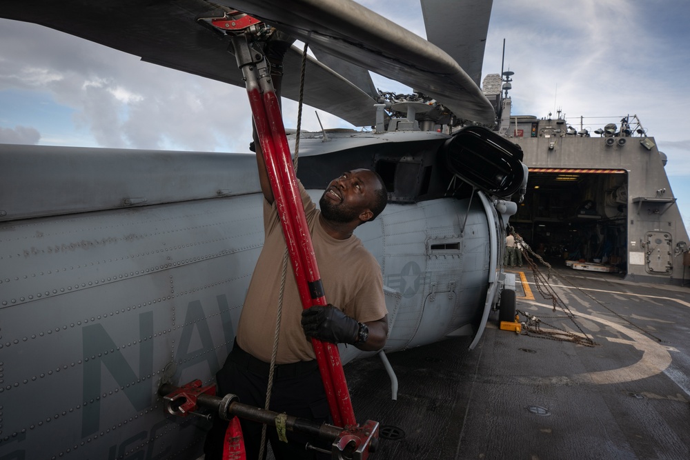 HSC 22 Sailor Prepares to Spread the Rotor Blades an MH-60S Sea Hawk Helicopter