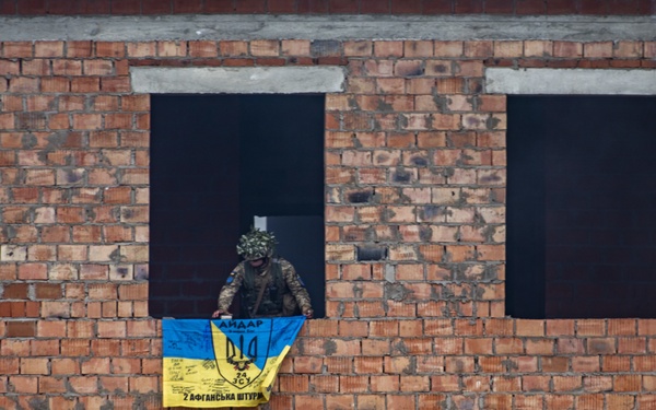Ukrainian soldier puts flag on cleared building during Rapid Trident 21