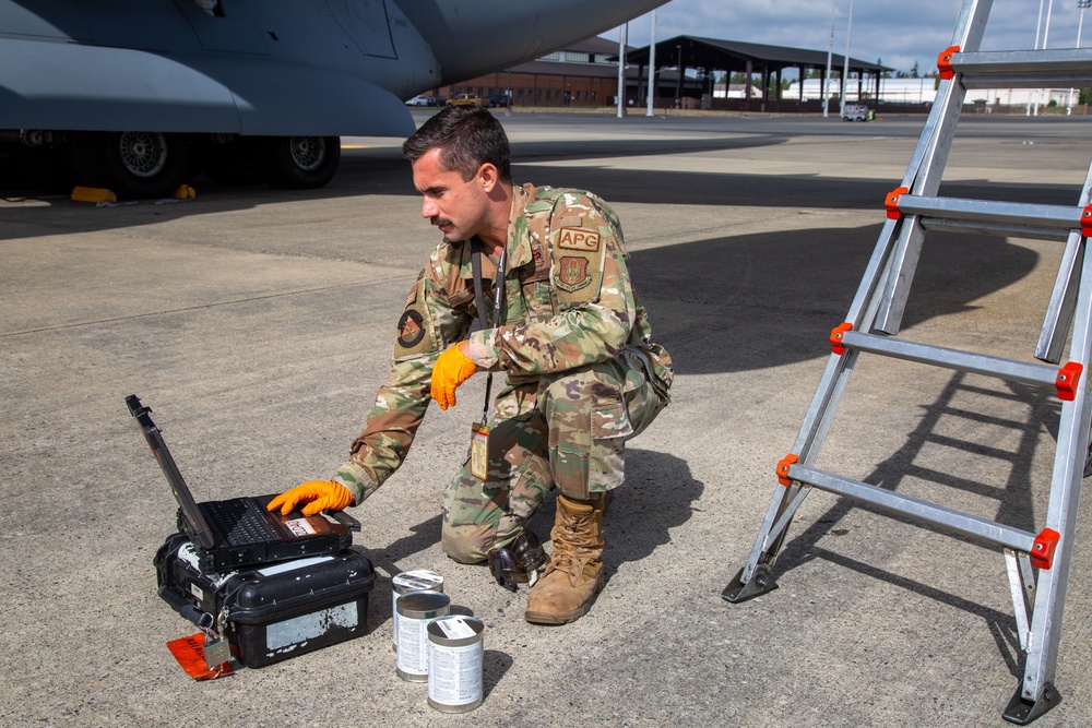 A Reservist services oil to a C-17 Globemaster III