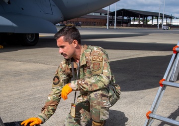 A Reservist services oil to a C-17 Globemaster III