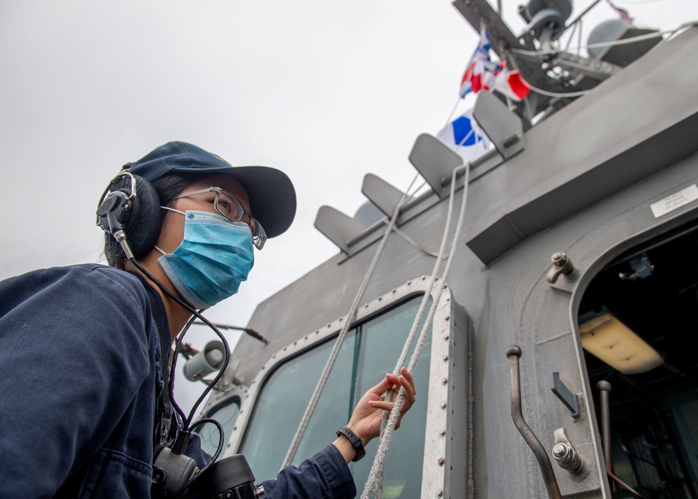 USS Charleston Sailor Lowers Nautical Flags