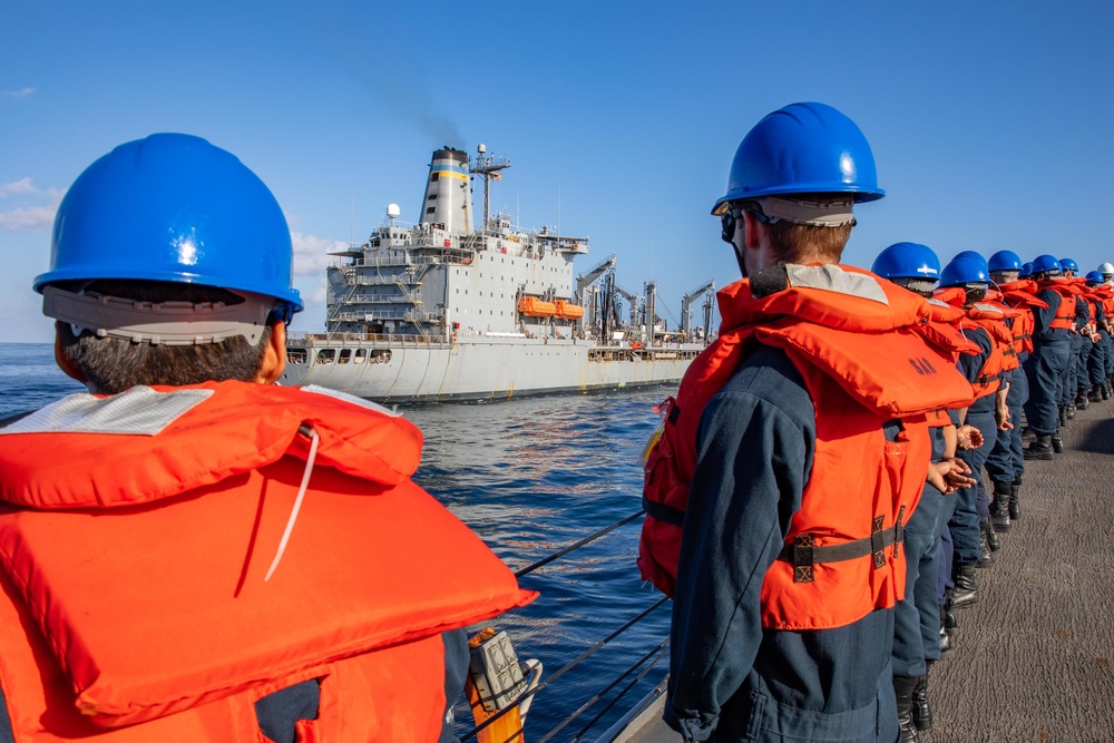Sailors aboard the USS Barry Man the Rails during a Replenishment-at-sea with USNS Tippecanoe