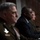 SECDEF, CJCS, CENTCOM Senate Armed Services Testimony Three individuals are seated at what appears to be a formal hearing or official proceeding, likely governmental or military in nature. Two of the individuals are wearing military uniforms with visible insignia and patches, while the central figure is dressed in a dark civilian suit with a blue tie. The setting suggests a congressional hearing or high-level official briefing.