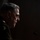 SECDEF, CJCS, CENTCOM Senate Armed Services Testimony A military officer in profile view is seated at what appears to be a hearing or formal proceeding, illuminated by dramatic side lighting against a dark background. The individual is wearing a military dress uniform with visible unit insignia. A microphone is positioned in front of them.