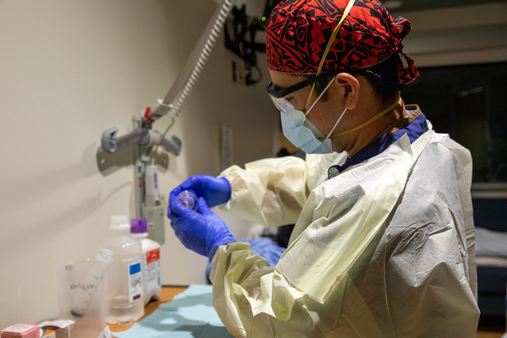 U.S. Army Medical Response Team Member Provides Medication to COVID Positive Patient