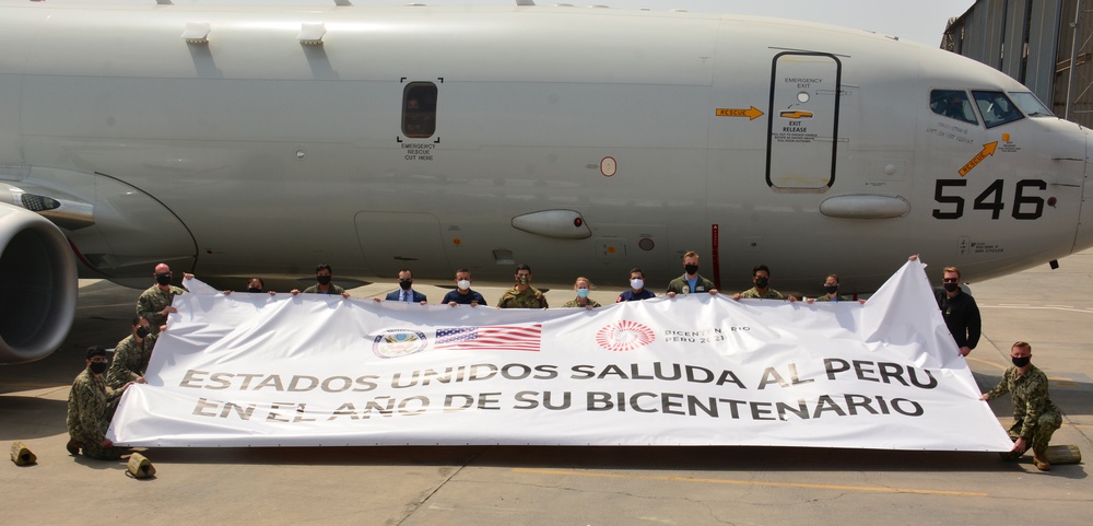 Multinational service members and distinguished visitors pose for a photo