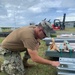 US Navy Seabees assigned to NMCB-5 prepare to build a gas cylinder storage unit
