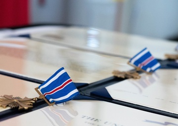 Adm. Karl Schultz, the commandant of the Coast Guard, presents awards to members of Air Station Cape Cod