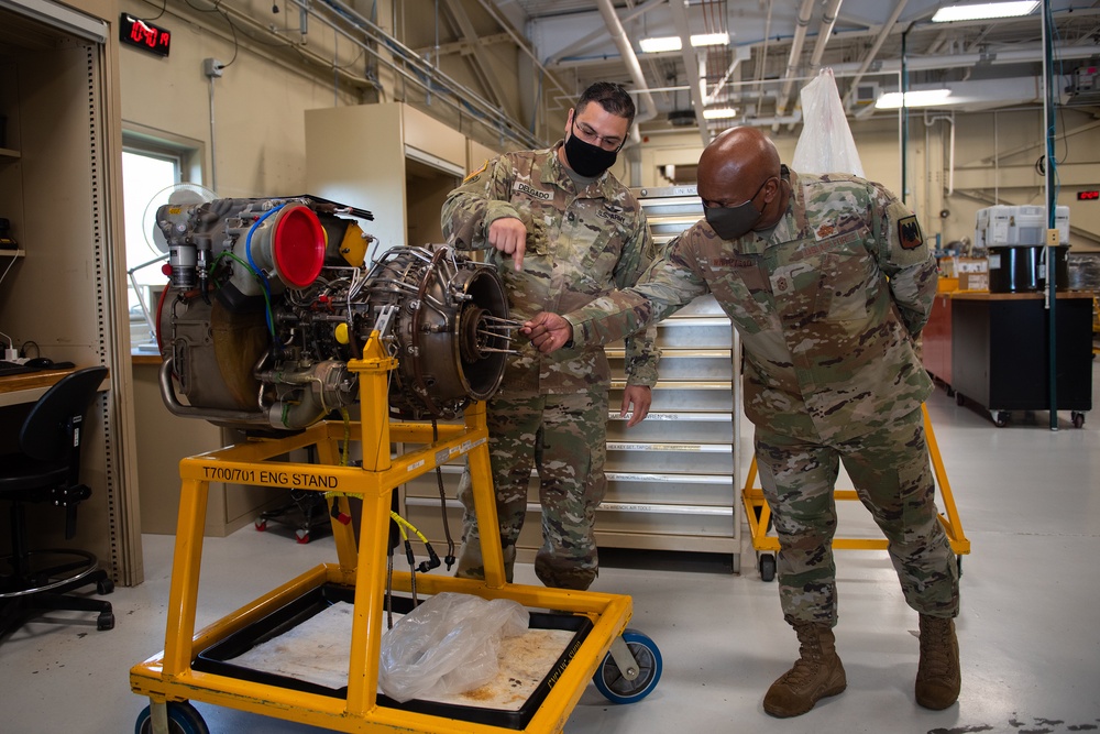 U.S. Army Sgt. 1st Class David Delgado, left, engine shop platoon sergeant, 1109th Theater Aviation Sustainment Maintenance Group (TASMG), Connecticut National Guard, discusses a T700 engine with Senior Enlisted Advisor Tony Whitehead, senior enlisted advisor to the Chief of the National Guard Bureau, during a tour of the engine shop, in New London, Connecticut, Oct. 8, 2021.