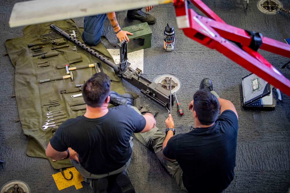 USS Charleston Sailors Conduct Maintenance on a GAU Machine Gun