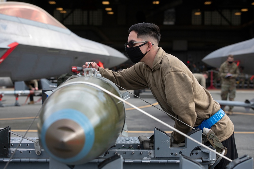 525th Aircraft Maintenance Unit Airmen arm F-22 Raptors during the Weapons Load Crew of the Quarter competition