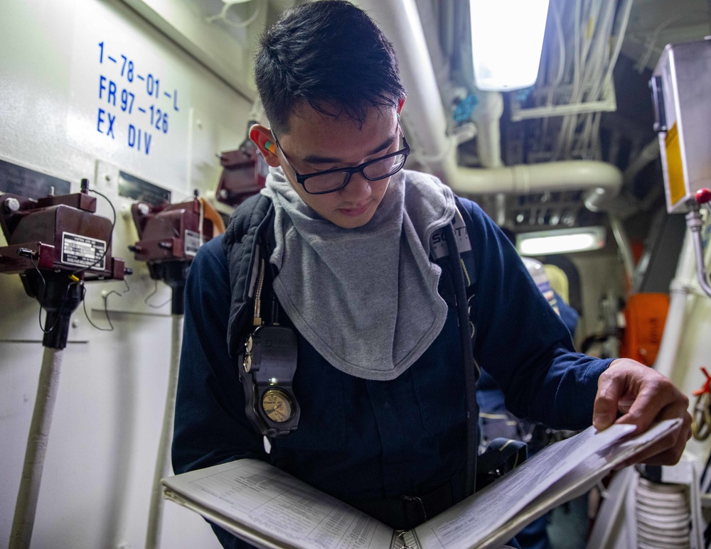 ETFN Christian Arzola Reads the Electical Isolation Guide aboard the USS Dewey during a General Quarters Drill