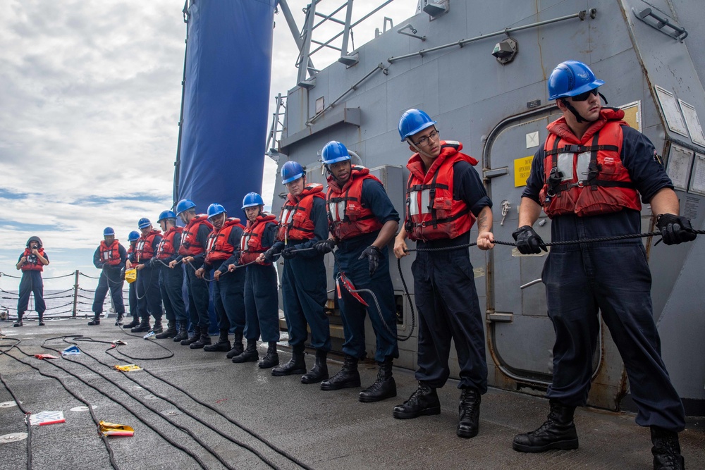 Sailors aboard the USS Dewey Heave a Phone and Distance Line during a Replenishment-at-sea