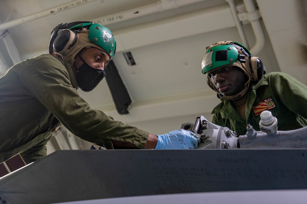 Airman Ousainou Jammeh and AD2 Sirkaylon Morgan Conduct Preventive Maintenence on an MH-60R Helicopter