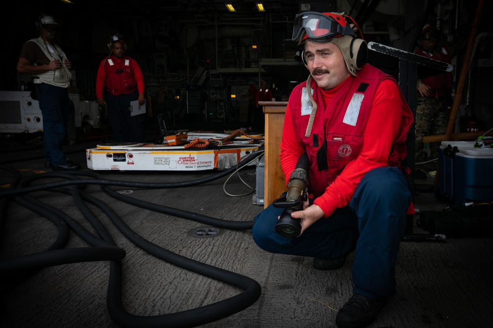 USS Sioux City Sailor Tests for Extinguishing Agent During a Flight Deck Fire Drill