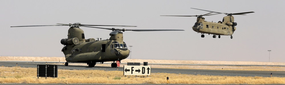 Chinook helicopters from C Co, 1-171 Aviation Regiment land at Camp Buehring