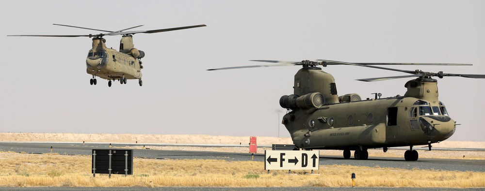 Chinook helicopters from C Co, 1-171 Aviation Regiment land at Camp Buehring