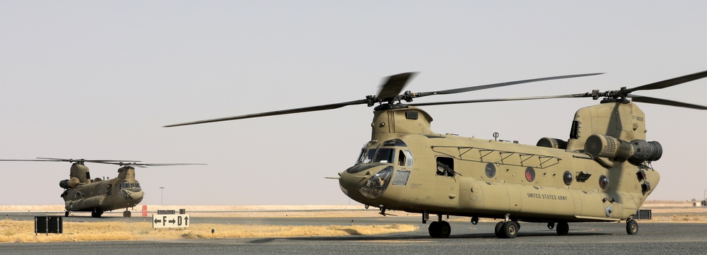 Chinook helicopters from C Co, 1-171 Aviation Regiment land at Camp Buehring