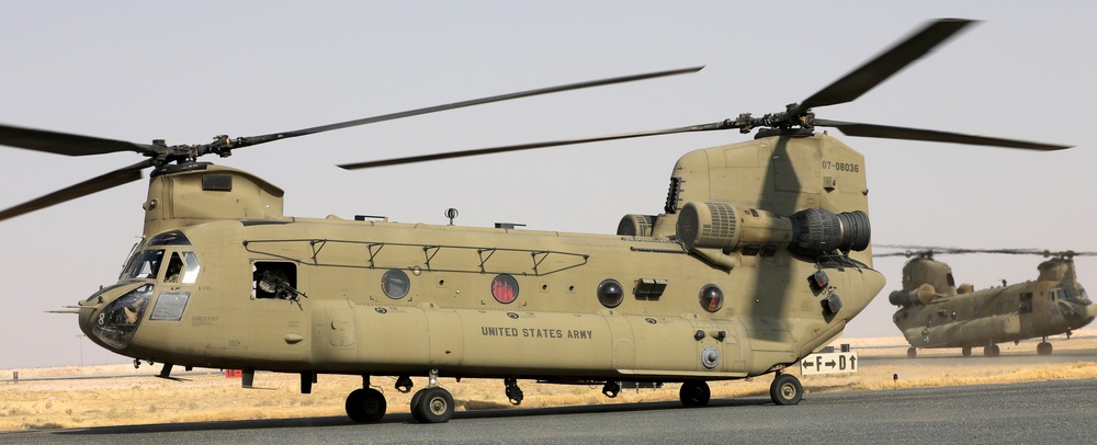 Chinook helicopters from C Co, 1-171 Aviation Regiment land at Camp Buehring