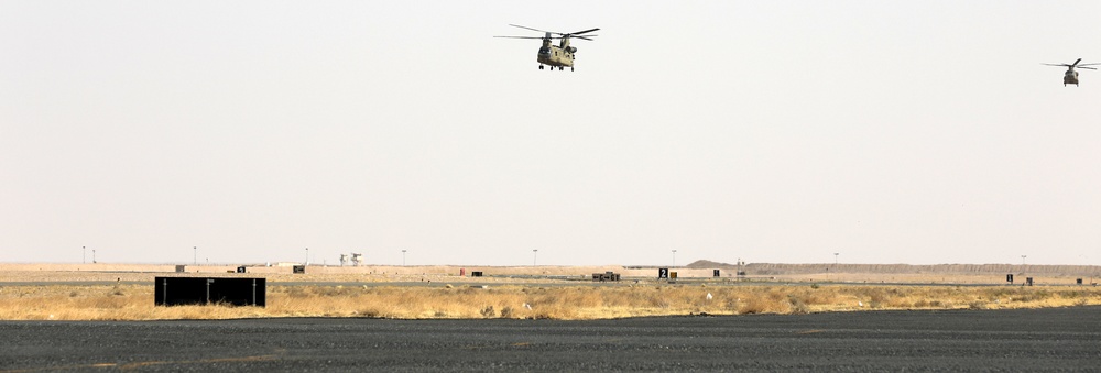 Chinook helicopters from C Co, 1-171 Aviation Regiment land at Camp Buehring