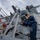 ENS Noah Spahr Sweeps the Deck of the Ship during a Fresh Water Wash-down aboard USS Dewey